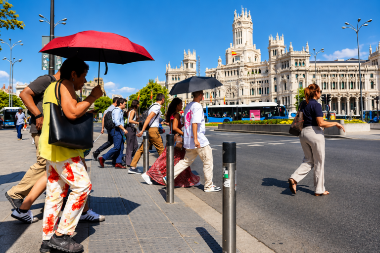 Personas caminando bajo altas temperaturas durante una ola de calor en España.